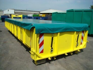 Gelber Abfallcontainer mit einer grünen Abdeckung und reflektierenden Streifen auf der Vorderseite.