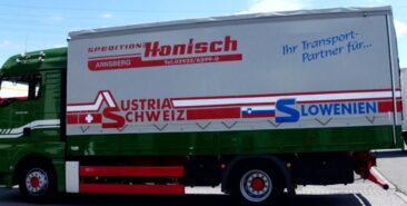 Grüner Lkw der Spedition Honisch mit Aufschrift für Transportdienstleistungen in Österreich und Slowenien.