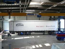 Ein Kermi Lkw mit der Aufschrift 'Heizen + Duschen' in einer Lagerhalle.