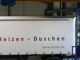 Seitenansicht eines Lkw mit der Aufschrift 'Heizen + Duschen' und der Website www.kermi.de.
