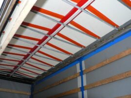 Innenansicht eines Lkw mit einem strukturierten Deckenaufbau und orangefarbenen Elementen.