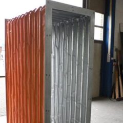 Individuelle Planenstruktur mit orangefarbenem und silbernem Vorhang in einem Innenraum.