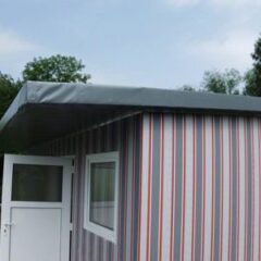 Ein Gebäude mit gestreifter Außenverkleidung in Grau, Rot und Weiß und einem flachen Dach.