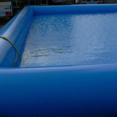 Blaues aufblasbares Schwimmbecken mit Wasser gefüllt und gelbem Schlauch.